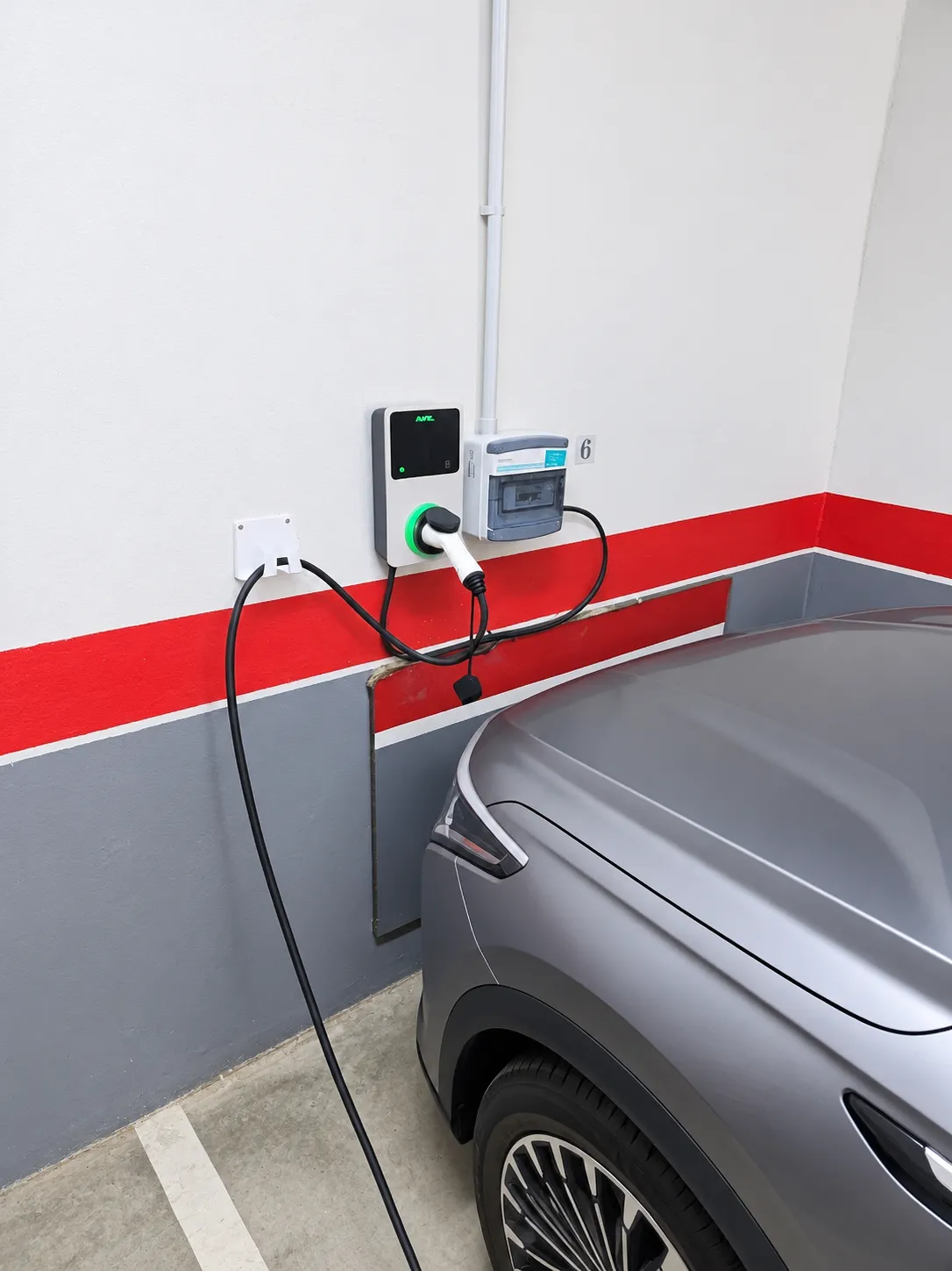 Coche eléctrico cargando en un garaje comunitario con un cargador instalado por nuestro equipo